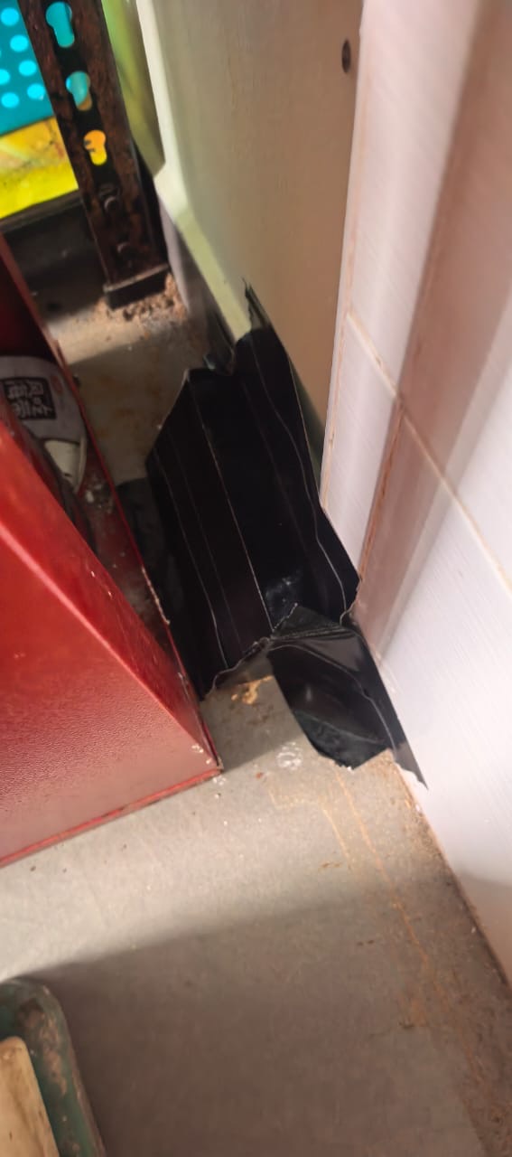 A bait station taped into the corner beside a door frame